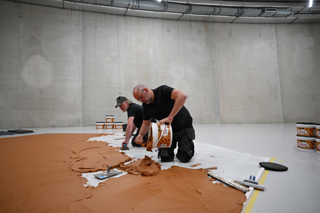 Workers spread peanut butter on a floor to recreate the "Peanut Butter Floor" artwork in tribute to Dutch artist Wim T. Schippers at the Museum Boijmans Van Beuningen in Rotterdam, Netherlands, Friday, July 3, 2026. (AP Photo/Mouneb Taim)