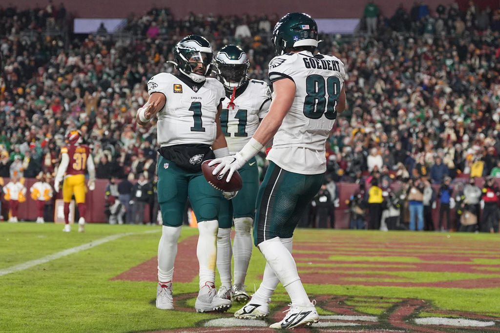 Philadelphia Eagles tight end Dallas Goedert (88) celebrates with quarterback Jalen Hurts (1) after scoring a touchdown against the Washington Commanders during the second half of an NFL football game, Saturday, Dec. 20, 2025, in Landover, Md. (AP Photo/Stephanie Scarbrough)