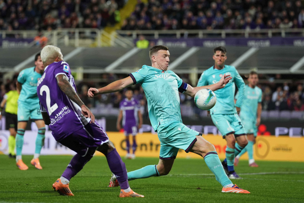 Fiorentina's Dodo, left, looks at Bologna's Lewis Ferguson touching the ball with his hand in the penalty box, during the Italian Serie A soccer match between Fiorentina and Bologna, in Florence, Italy, Sunday, Oct. 26, 2025. (Massimo Paolone/LaPresse via AP)