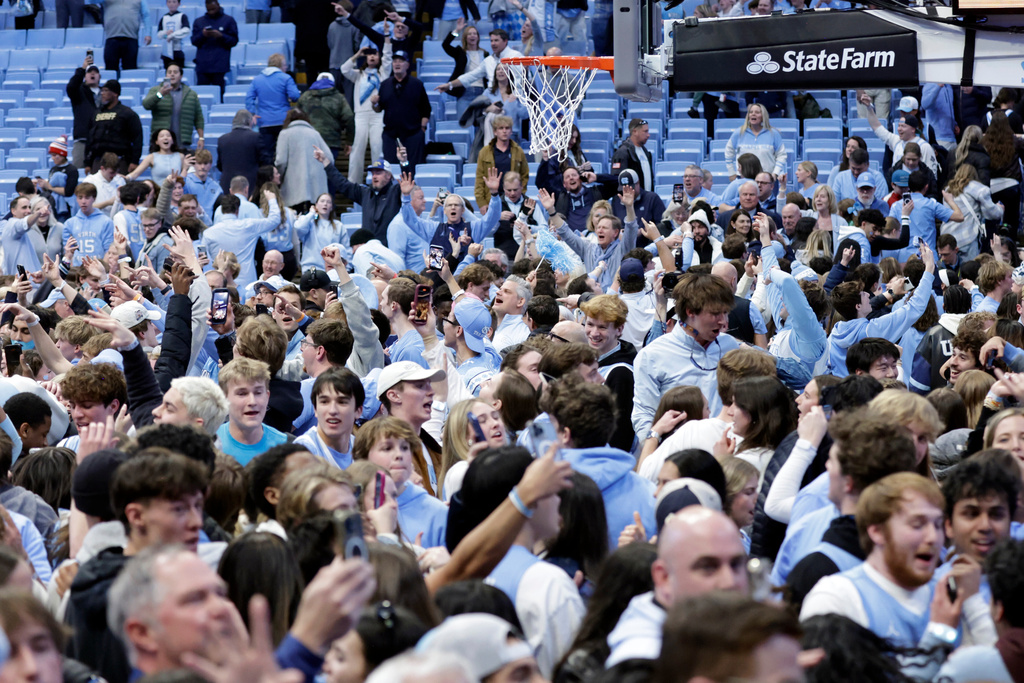 North Carolina fans take the floor and celebrate after the team defeated Duke in the final seconds of an NCAA college basketball game Saturday, Feb. 7, 2026, in Chapel Hill, N.C. (AP Photo/Chris Seward)