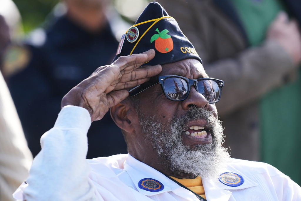US Army veteran Ronnie Rumph salutes as he sings the national anthem during a Veterans Day ceremony at a cemetery in the Esther Mae Armbrister Park in the Coconut Grove neighborhood of Miami, Tuesday, Nov. 11, 2025. (AP Photo/Lynne Sladky)