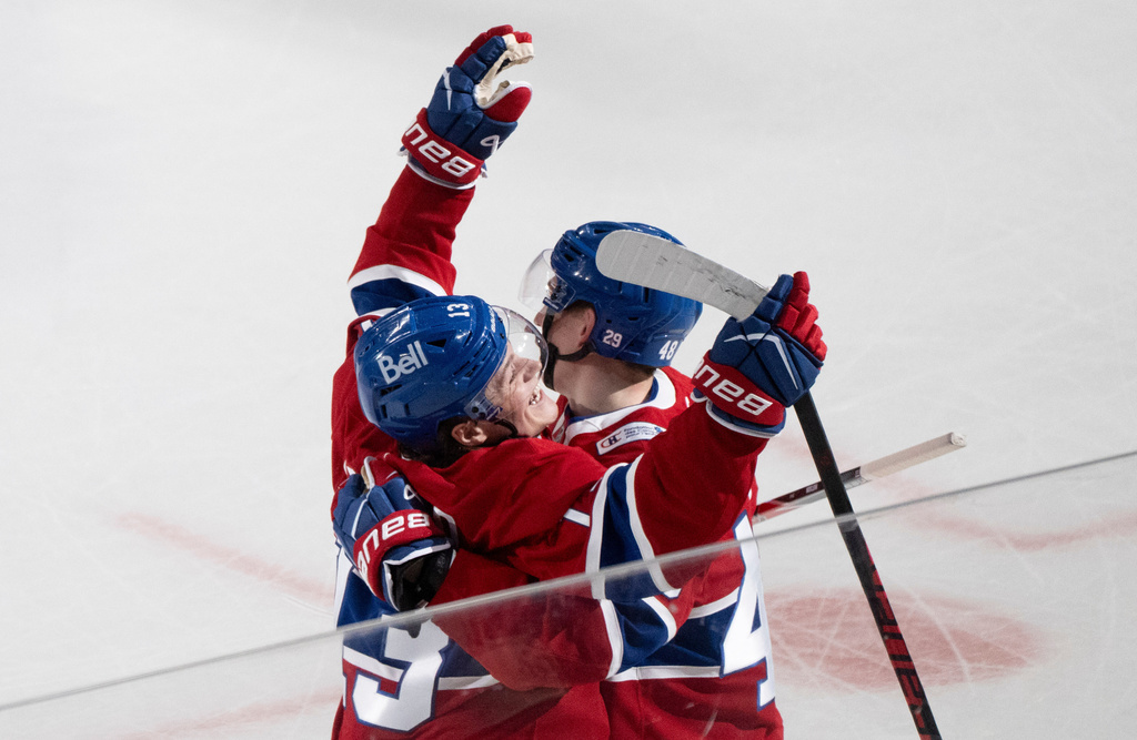 Montreal Canadiens' Cole Caufield (13) celebrates his goal over the Boston Bruins with teammate Lane Hutson (48) during overtime NHL hockey action in Montreal on Tuesday, March 17, 2026. (Christinne Muschi/The Canadian Press via AP)