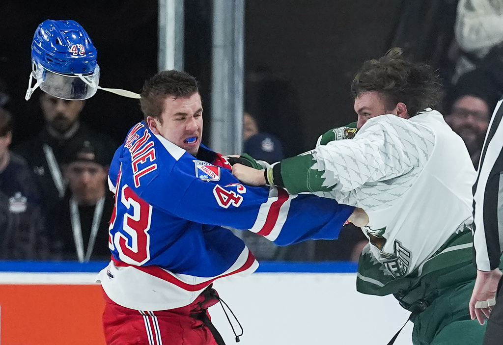 Kitchener Rangers' Andrew MacNiel, left, loses his helmet as he and Everett Silvertips' Jaxsin Vaughan fight during the second period of a Memorial Cup hockey game in Kelowna, British Columbia, Monday, May 25, 2026. (Darryl Dyck/The Canadian Press via AP)