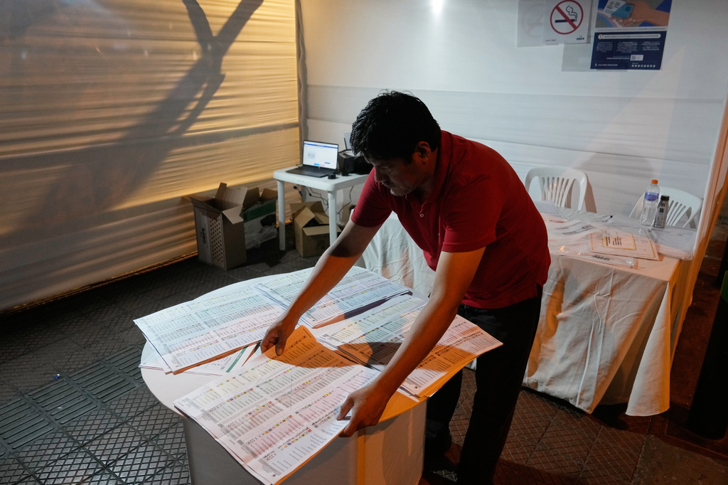 An electoral official count ballots at a polling station during general elections in Lima, Peru, Sunday, April 12, 2026. (AP Photo/Martin Mejia)