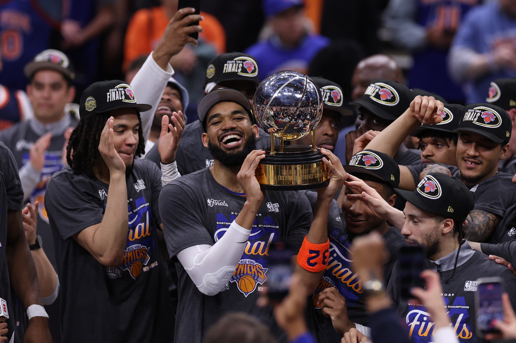 New York Knicks center Karl-Anthony Towns, center, and teammates celebrate after winning Game 4 in the Eastern Conference finals NBA basketball playoffs series against the Cleveland Cavaliers in Cleveland, Monday, May 25, 2026.(AP Photo/Tim Phillis)