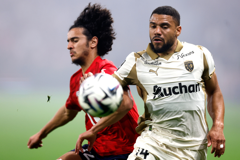 Lille's Ayyoub Bouaddi, left, and Lens' Jonathan Gradit challenge for the ball during the French League One soccer match between Lille and Lens, in Lille, France, Saturday, April 4, 2026. (AP Photo/Jean-Francois Badias)