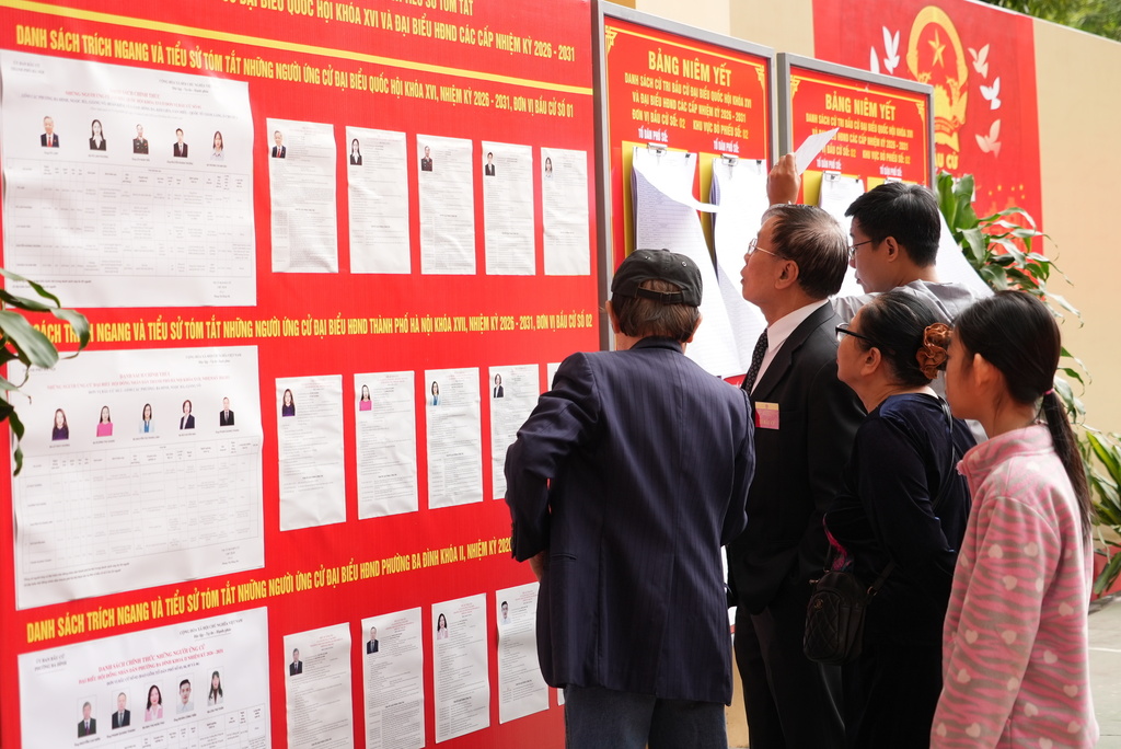 Voters check profiles of candidates before casting ballots to elect representatives in the National Assembly and people's councils in Hanoi, Vietnam, Sunday, March 15, 2026. (AP Photo/Hau Dinh)