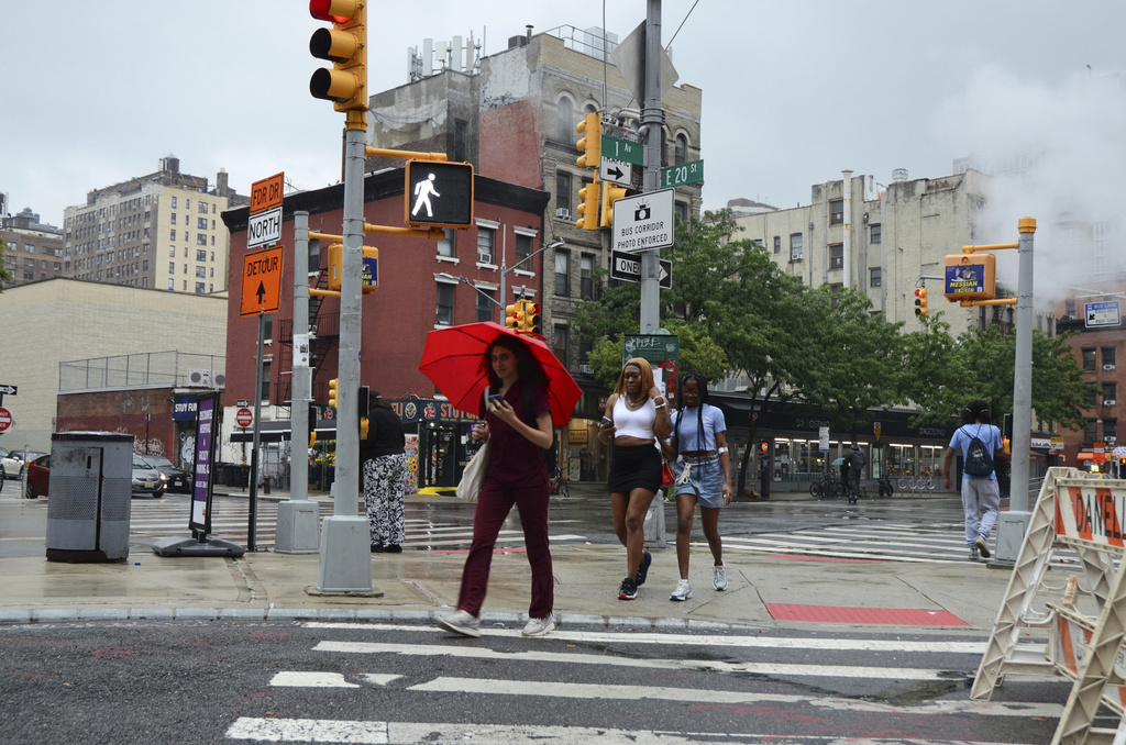 FILE - Pedestrians walk in the rain on 20th Street and First Avenue, Thursday, July 31, 2025, in New York. (AP Photo/Pamela Hassell, file)