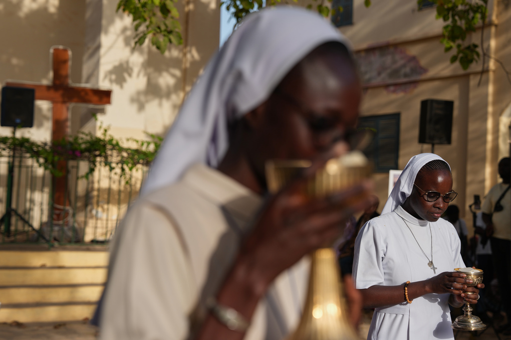 Catholic sisters participate in the the distribution of Holy Communion during a service marking Good Friday at the Saint Charles church on Goree Island, Senegal, Friday, April 3, 2026. (AP Photo/Misper Apawu)
