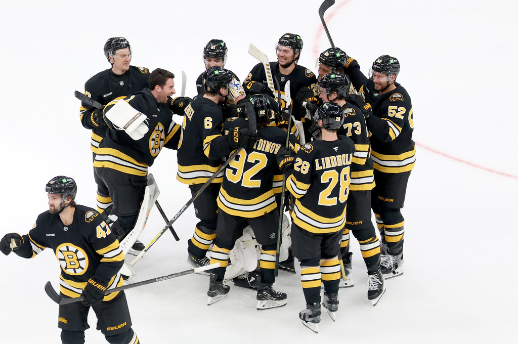 Boston Bruins celebrate after their win in overtime against the Chicago Blackhawks during an NHL hockey game, Thursday, Oct. 9, 2025, in Boston. (AP Photo/Mark Stockwell)