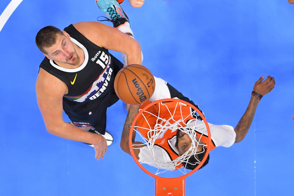 Denver Nuggets center Nikola Jokic, left, watches his shot as Los Angeles Clippers forward Derrick Jones Jr. defends during the second half of an NBA basketball game Wednesday, Nov. 12, 2025, in Inglewood, Calif. (AP Photo/Mark J. Terrill)