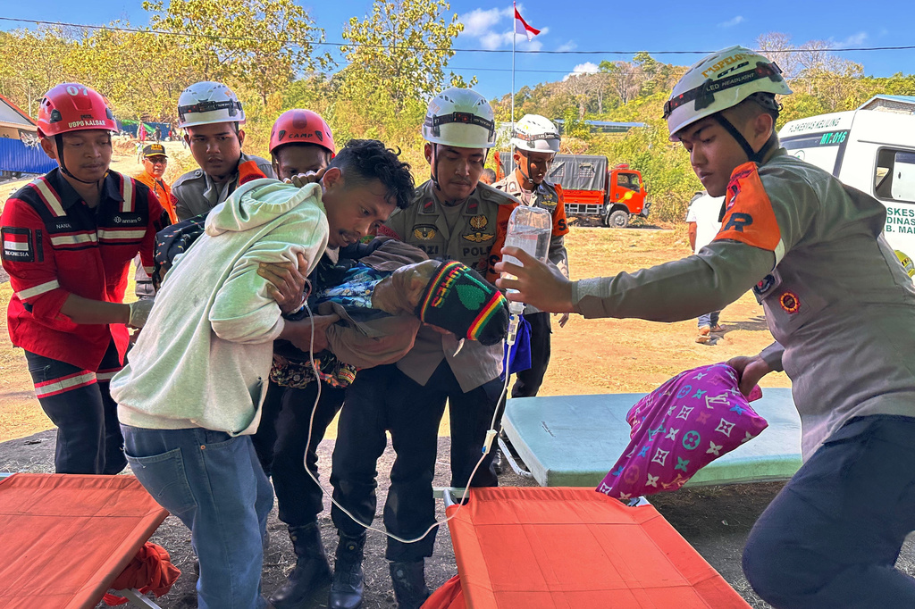 Rescuers evacuate a person injured in an earthquake in North Lamba Leda, East Nusa Tenggara province, Indonesia, Tuesday, Aug. 18, 2026. (AP Photo/Firdia Lisnawati)