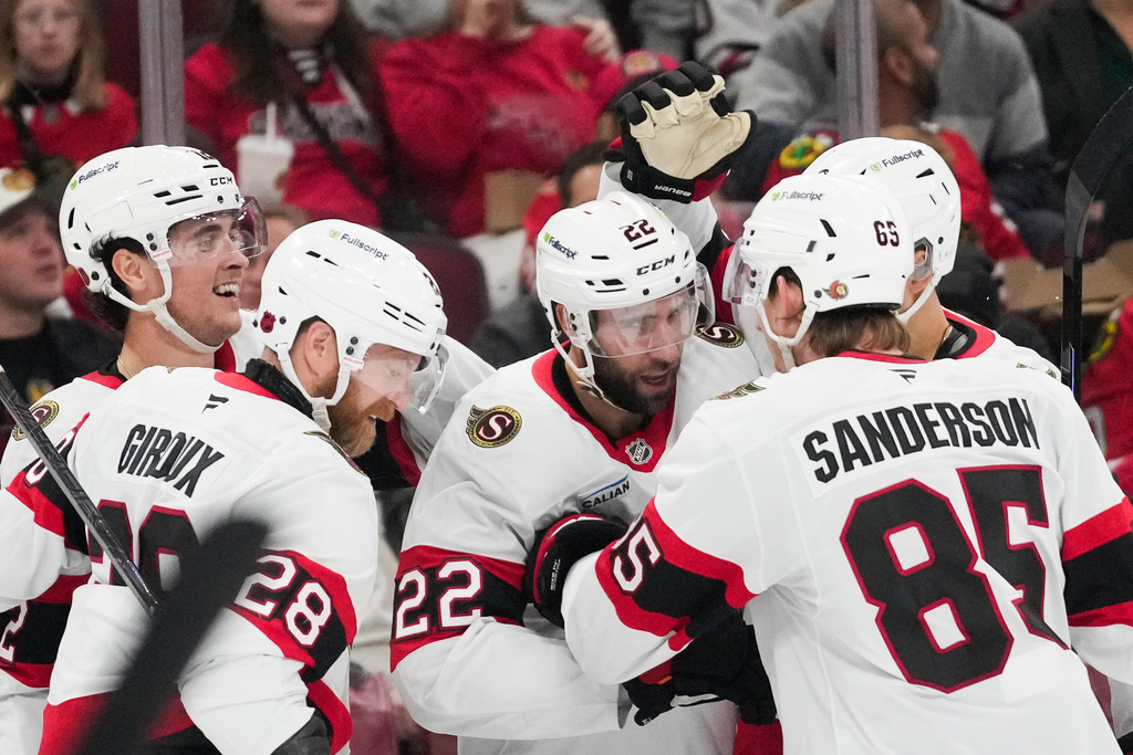 Ottawa Senators right wing Michael Amadio (22), center, celebrates his goal on Chicago Blackhawks goaltender Spencer Knight during the second period of an NHL hockey game, Tuesday, Oct. 28, 2025, in Chicago. (AP Photo/Erin Hooley)