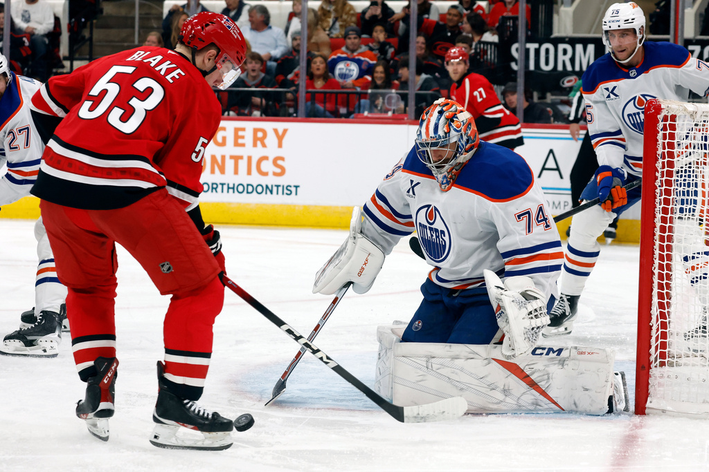 Carolina Hurricanes' Jackson Blake (53) tries to gather in the puck in front of Edmonton Oilers goaltender Stuart Skinner (74) during the second period of an NHL hockey game in Raleigh, N.C., Saturday, Nov. 15, 2025. (AP Photo/Karl DeBlaker)