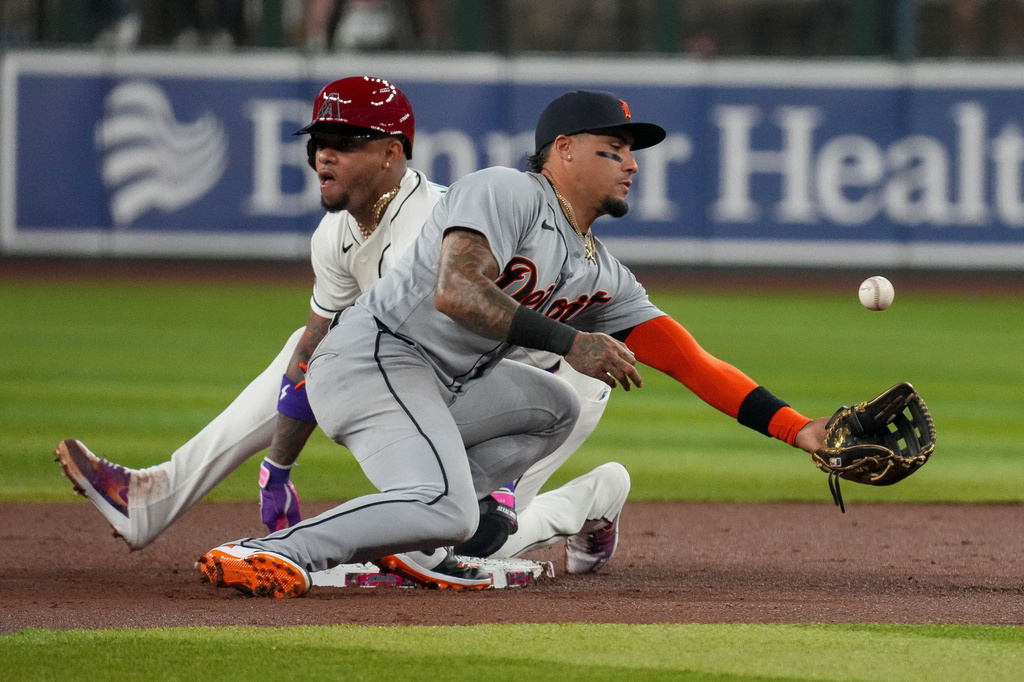 Arizona Diamondbacks' Ketel Marte, left, slides safely into second base as Detroit Tigers shortstop Javier Báez bobbles the ball during a steal attempt in the first inning of an opening-day baseball game Monday, March 30, 2026, in Phoenix. (AP Photo/Darryl Webb)