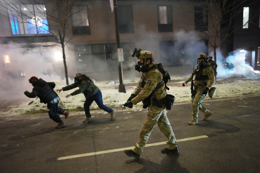 Federal agents try to clear demonstrators near a hotel, using tear gas during a noise demonstration protest in response to federal immigration enforcement operations in the city Sunday, Jan. 25, 2026, in Minneapolis. (AP Photo/Adam Gray)