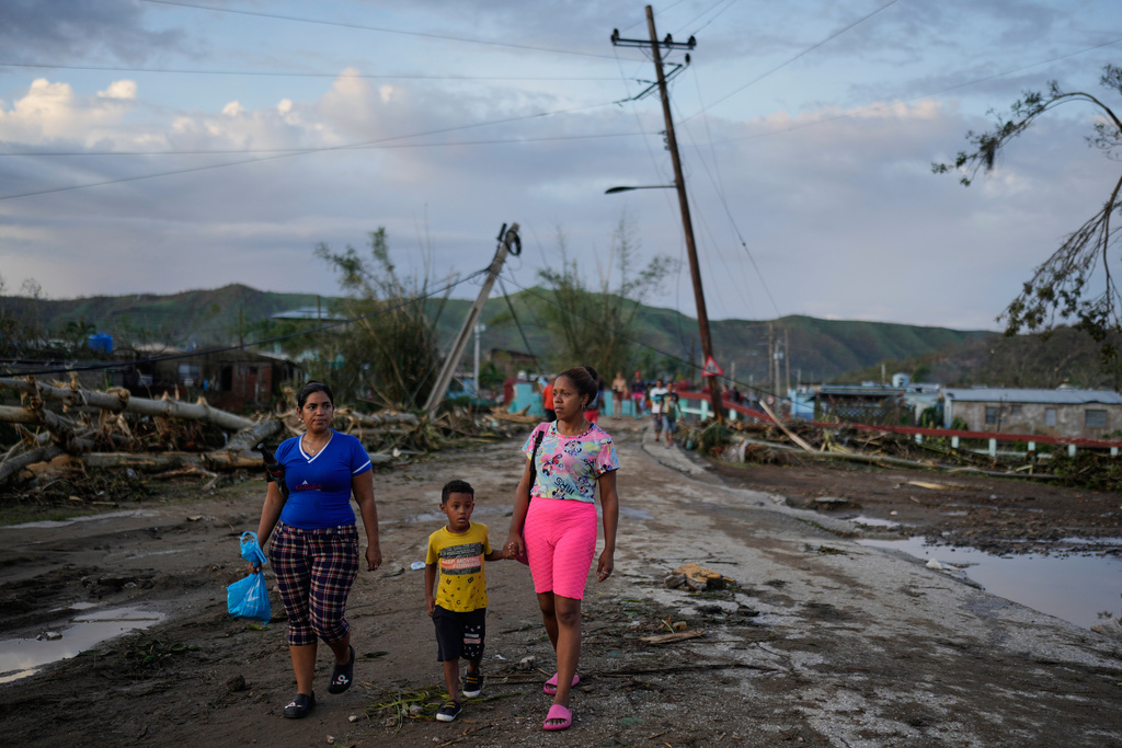 Residents walk in the aftermath of Hurricane Melissa in El Cobre, Cuba, Wednesday, Oct. 29, 2025. (AP Photo/Ramon Espinosa)