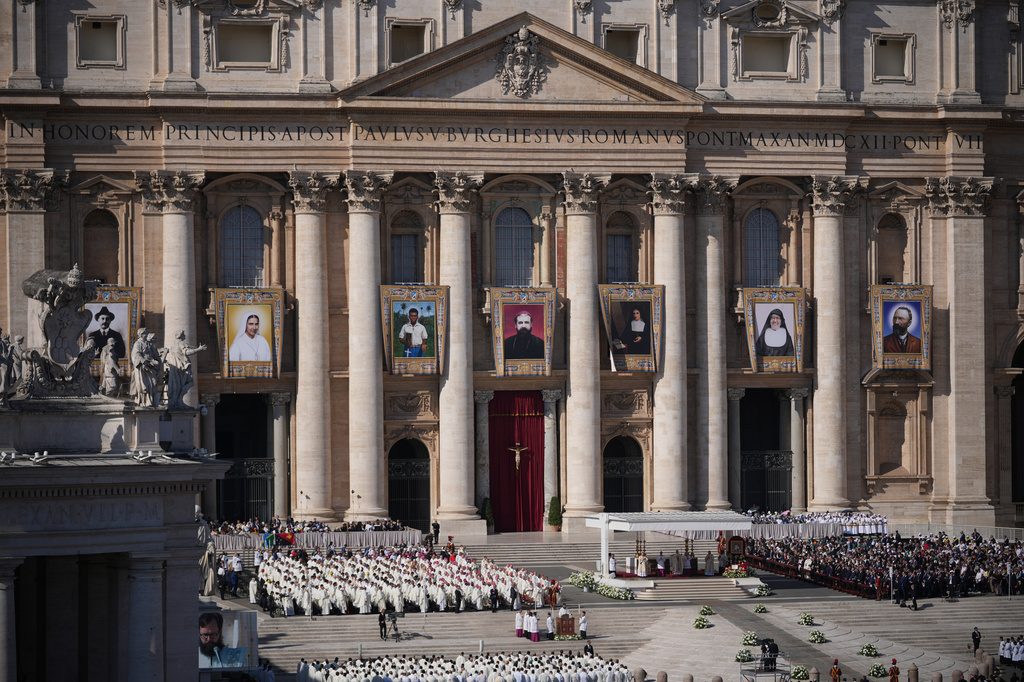 FILE - Tapestries depicting seven new Catholic saints hang from the facade of St. Peter's Basilica, as Pope Leo XIV presides over their canonization in St. Peter's Square at the Vatican, Oct. 19, 2025. (AP Photo/Andrew Medichini, File)