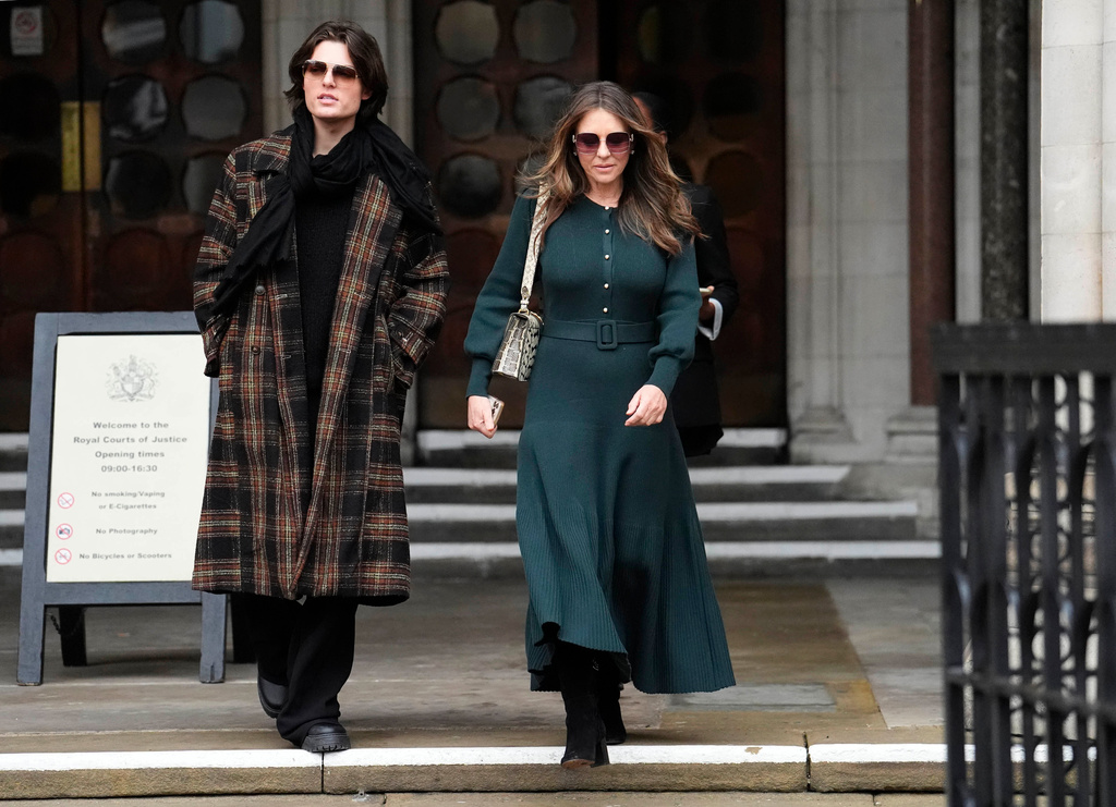 Elizabeth Hurley, right, leaves the Royal Courts of Justice on day four of the trial over allegations of unlawful information gathering brought against Associated Newspapers Limited, Thursday, Jan. 22, 2026, in London. (Jordan Pettitt/PA via AP)