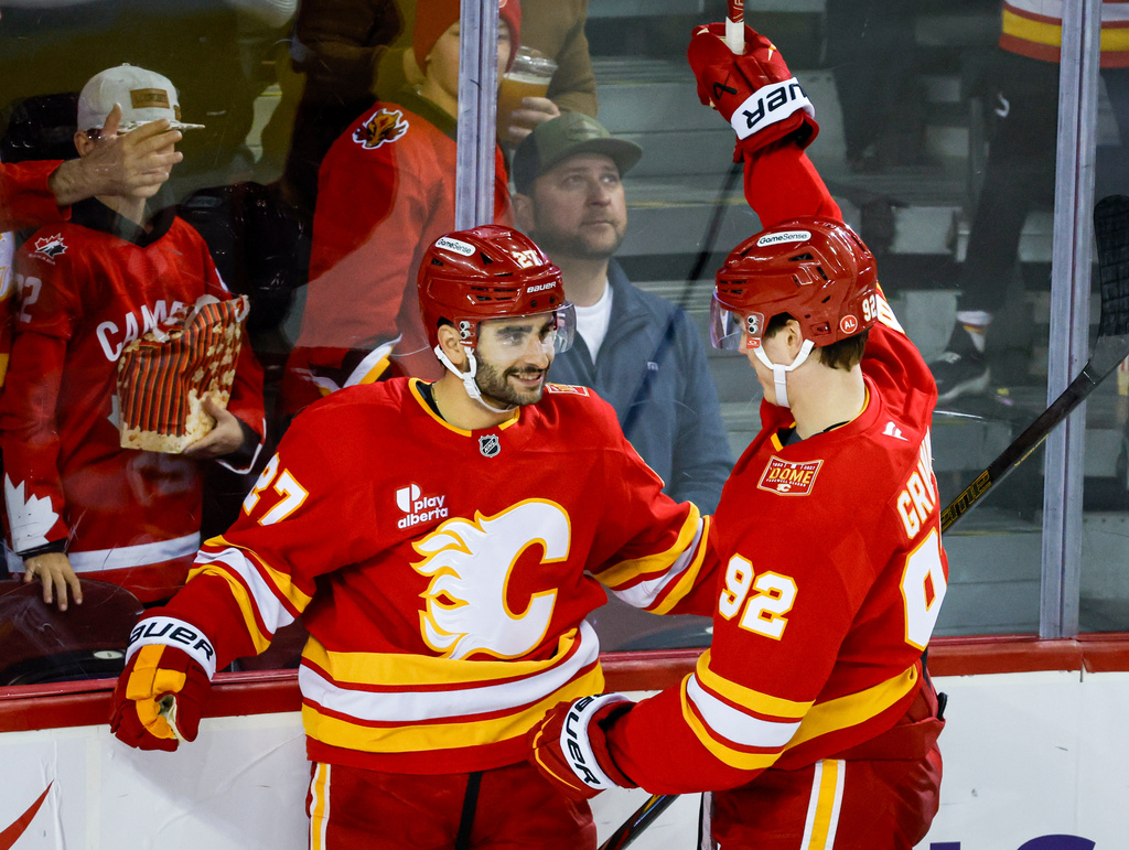 Calgary Flames' Matt Coronato, left, celebrates after his goal with teammate Matvei Gridin, right, during the third period of an NHL hockey game against the Seattle Kraken in Calgary, Alberta, Friday, Oct. 30, 2026. (Jeff McIntosh/The Canadian Press via AP)
