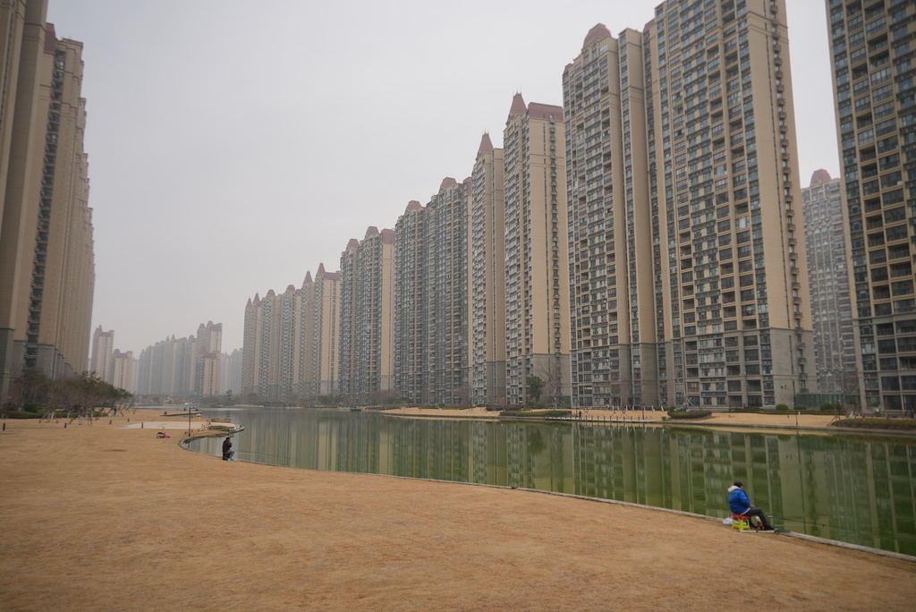 Residents fish in an artificial canal at the semi-abandoned "Life in Venice" housing complex in Qidong, on China's east coast, Feb. 5, 2026. (AP Photo/Dake Kang)