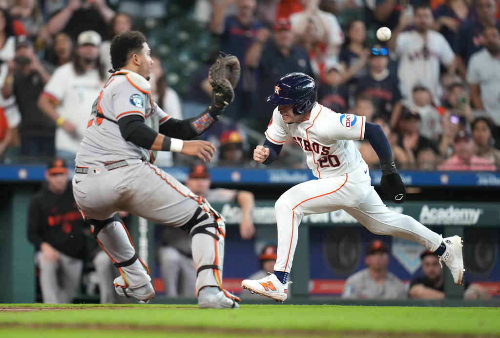 Houston Astros' Nick Allen is tagged out at the plate by Baltimore Orioles catcher Samuel Basallo as Jose Altuve flied into a double play during the tenth inning of a baseball game, Saturday, July 18, 2026, in Houston. (AP Photo/Karen Warren)