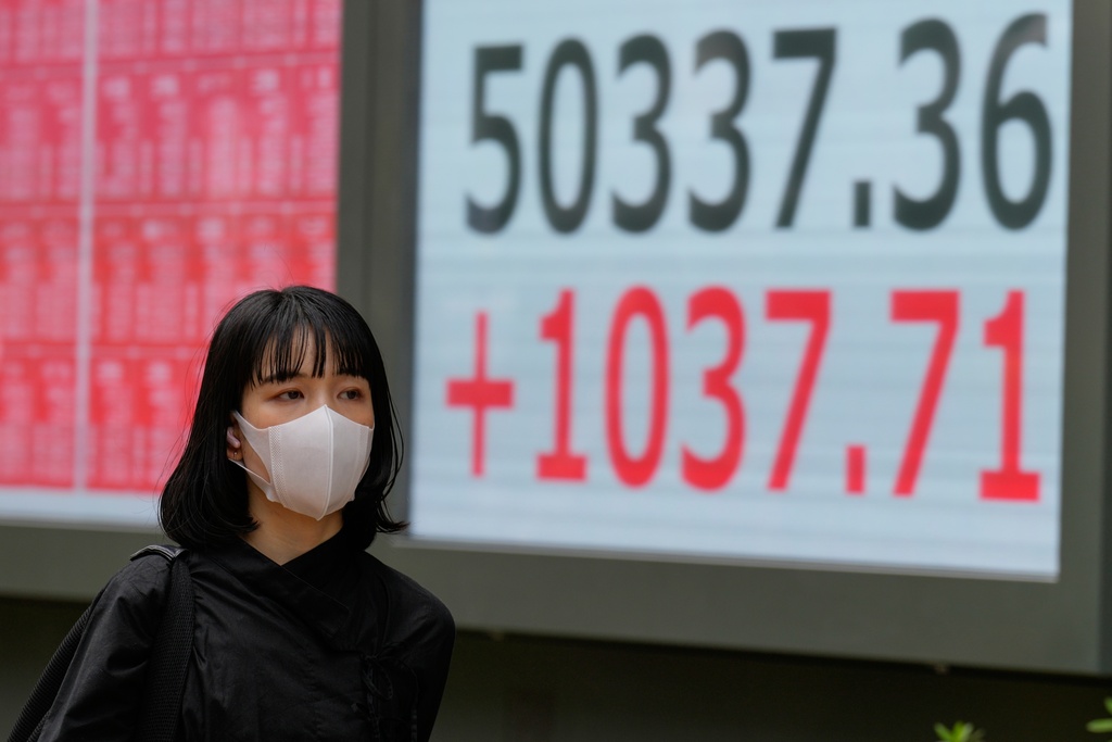 A person walks in front of an electronic stock board showing Japan's Nikkei index at a securities firm Monday, Oct. 27, 2025, in Tokyo. (AP Photo/Eugene Hoshiko)
