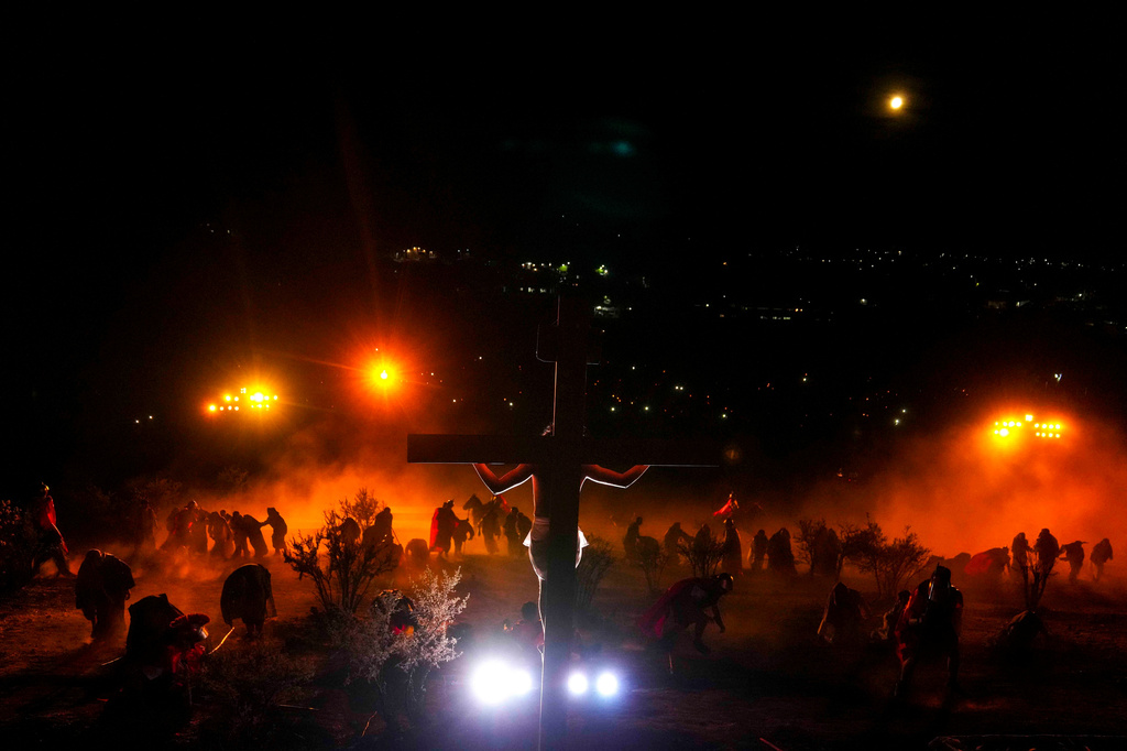 David Sanchez, playing the role of Jesus Christ, hangs on a cross in a Way of the Cross reenactment as part of Holy Week celebrations, in Colina, Chile, on Good Friday, April 3, 2026. (AP Photo/Esteban Felix)