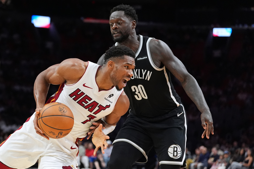Miami Heat forward Giannis Antetokounmpo (7) drives past Brooklyn Nets forward Julius Randle (30) during the second half of an NBA preseason basketball game, Wednesday, Oct. 14, 2026, in Miami. (AP Photo/Rebecca Blackwell)