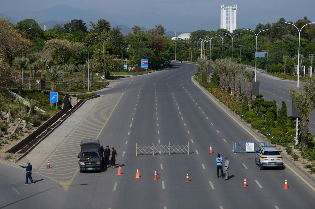 Police officers stand guard at a checkpoint on a barricaded road to ensure security ahead of the second round of the U.S. Iran officials talks, in Islamabad, Sunday, April 19, 2026. (AP Photo/M.A. Sheikh)