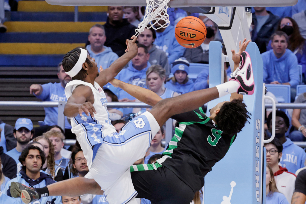 North Carolina forward Caleb Wilson, left, and USC Upstate guard Mason Bendinger (9) battle under the boards during the first half of an NCAA college basketball game Saturday, Dec. 13, 2025, in Chapel Hill, N.C. (AP Photo/Chris Seward)
