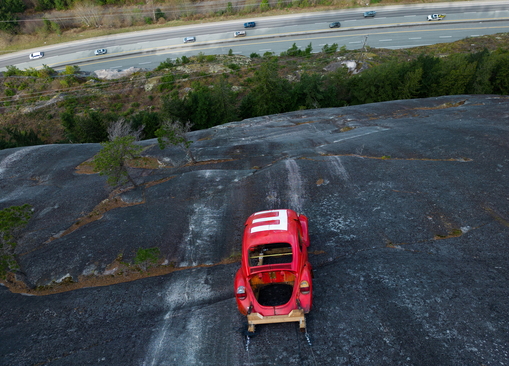The shell of a Volkswagen Beetle hangs suspended on a cliff above the Sea-to-Sky Highway, in Squamish, British Columbia, Monday, April 6, 2026, after it appeared on the rock face last week with a large "E" on its roof, indicating that University of British Columbia engineering students carried out a long-standing tradition of placing the shell in difficult to reach locations. (Darryl Dyck/The Canadian Press via AP)