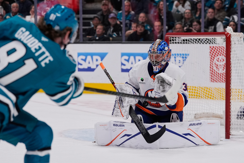 New York Islanders goaltender Ilya Sorokin (30) stops a shot by San Jose Sharks right wing Adam Gaudette, foreground, during the first period of an NHL hockey game, Saturday, March 7, 2026, in San Jose, Calif. (AP Photo/Godofredo A. Vásquez)