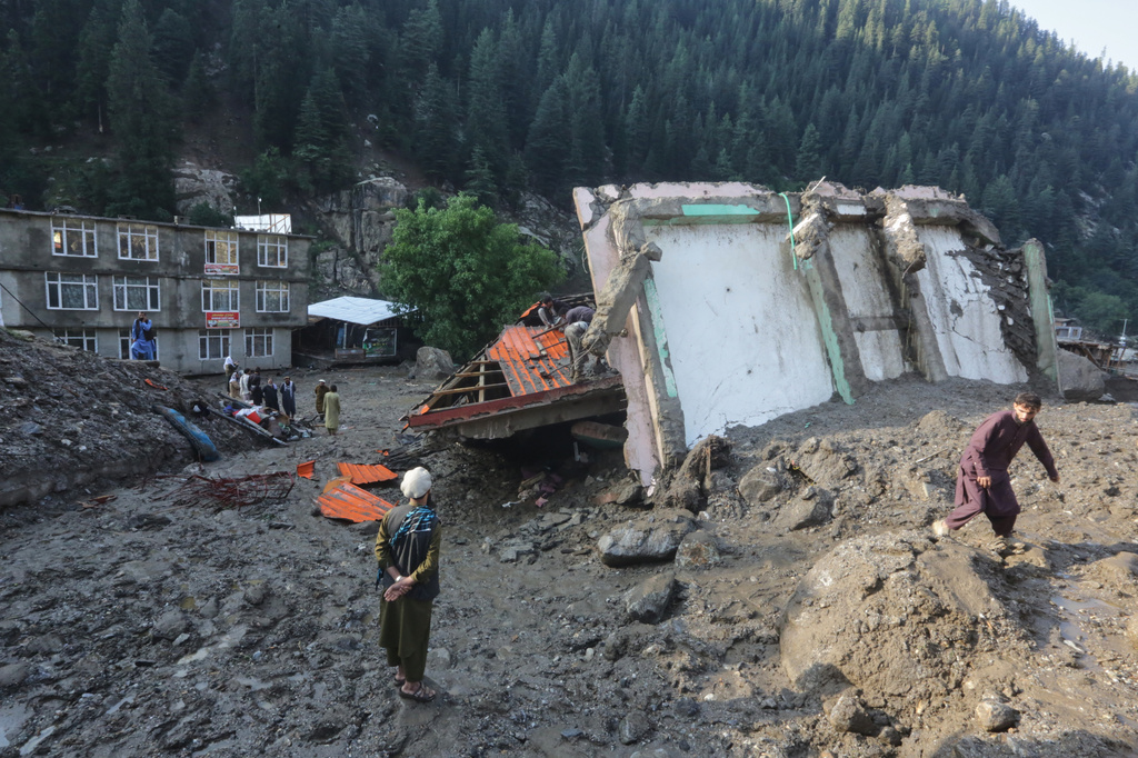 Residents and rescue workers inspect buildings destroyed by heavy flooding in the eastern province of Nuristan, Afghanistan, Tuesday, July 21, 2026. (AP Photo/Wahidullah Kakar)