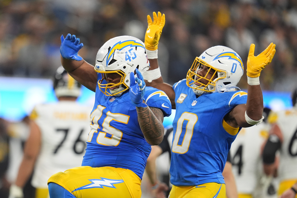 Los Angeles Chargers linebacker Tuli Tuipulotu (45) celebrates his sack with linebacker Daiyan Henley (0) during the second half of an NFL football against the Pittsburgh Steelers game Sunday, Nov. 9, 2025, in Inglewood, Calif. (AP Photo/Marcio Jose Sanchez)