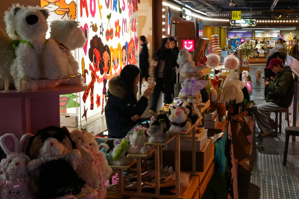 Shoppers walk by vendors waitingn for customers at their stores inside a shopping mall, in Beijing, Sunday, Nov. 30, 2025. (AP Photo/Andy Wong)