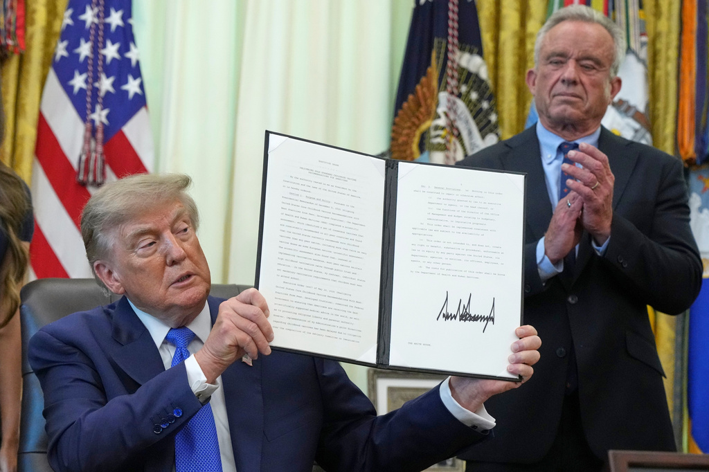 President Donald Trump holds a signed executive order about vaccines as Health and Human Services Secretary Robert F. Kennedy Jr. looks on, Monday, Aug. 10, 2026, in the Oval Office of the White House in Washington. (AP Photo/Jacquelyn Martin)