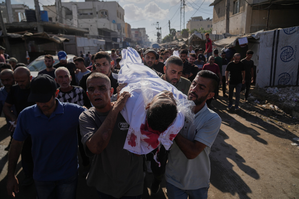 Palestinians carry the body of a man killed in an Israeli strike on Deir al-Balah, Gaza Strip, Wednesday, Oct. 1, 2025. (AP Photo/Abdel Kareem Hana)