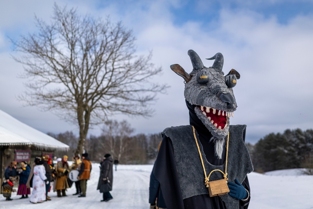 A man wearing traditional carnival masks takes part in Shrovetide celebrations in the village of Rumsiskes, some 89 kilometers (56 miles) north of Vilnius, Lithuania, Saturday, Feb. 14, 2026. (AP Photo/Mindaugas Kulbis)
