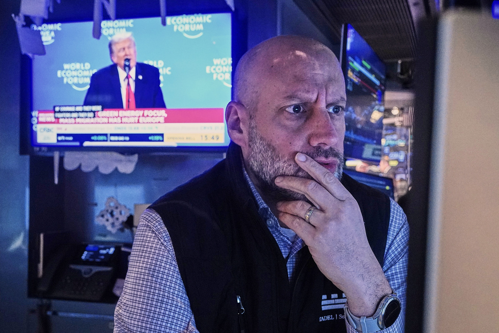 Specialist Meric Greenbaum works at his post on the floor of the New York Stock Exchange, as a television shows President Donald Trump speaking at the World Economic Forum, Wednesday, Jan. 21, 2026. (AP Photo/Richard Drew)