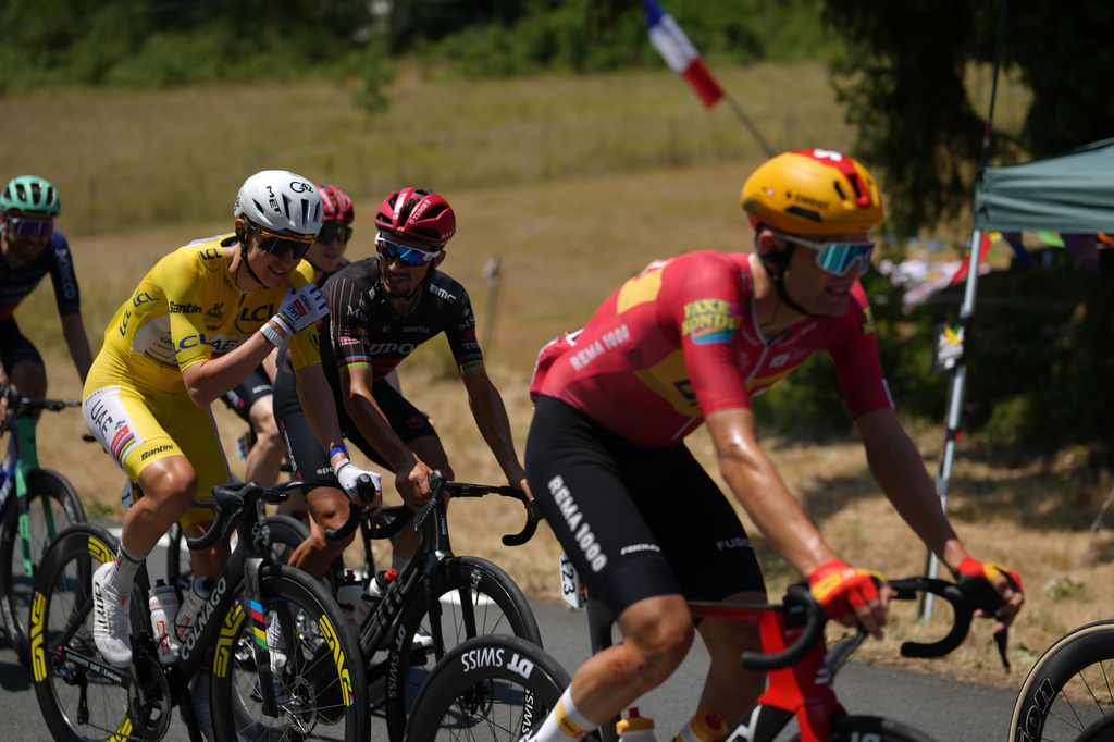 Slovenia's Tadej Pogacar, wearing the overall leader's yellow jersey, talks with France's Julian Alaphilippe, as they ride in the pack during the eighth stage of the Tour de France cycling race over 180.4 kilometers (111.8 miles) with start in Perigueux and finish in Bergerac, France, Saturday, July 11, 2026. (AP Photo/Thibault Camus)