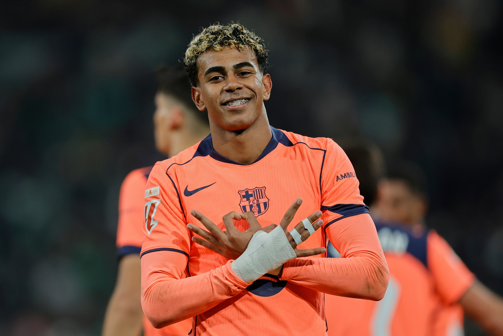 Barcelona's Lamine Yamal celebrates after scoring his sides 5th goal from the penalty spot during the Spanish La Liga soccer match between Real Betis and Barcelona in Seville, Spain, Saturday, Dec. 6, 2025. (AP Phot/Manu Reino)