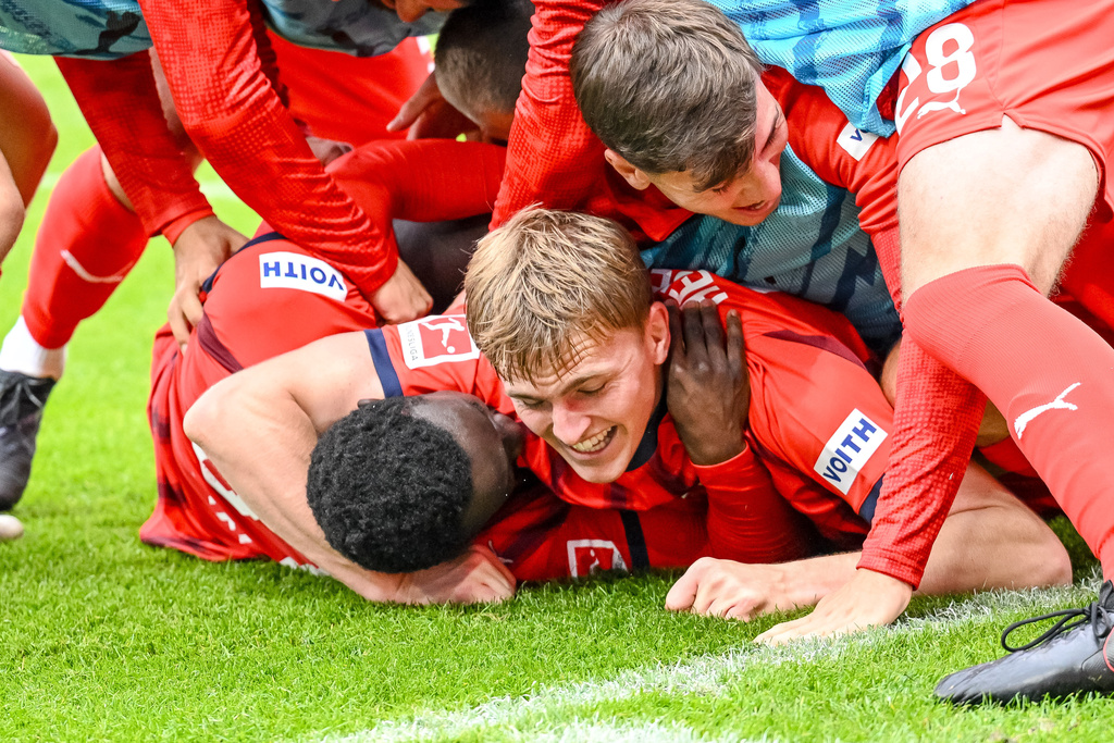 Heidenheim's Sirlord Conteh, bottom, celebrates with teammates after scoring during the German Bundesliga soccer match between FC Heidenheim and FC Augsburg at the Voith-Arena in Heidenheim, Germany, Saturday, Sept. 27, 2025. (Harry Langer/dpa via AP)