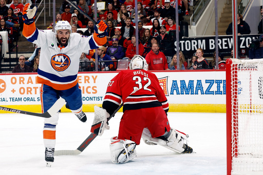 New York Islanders' Kyle Palmieri (21) celebrates a goal by teammate Matthew Schaefer, not shown, with Carolina Hurricanes goaltender Brandon Bussi (32) nearby during the first period of an NHL hockey game in Raleigh, N.C., Thursday, Oct. 30, 2025. (AP Photo/Karl DeBlaker) New York Islanders' Kyle Palmieri (21) celebrates a goal by teammate Matthew Schaefer, not shown, with Carolina Hurricanes goaltender Brandon Bussi (32) nearby during the first period of an NHL hockey game in Raleigh, N.C., Thursday, Oct. 30, 2025. (AP Photo/Karl DeBlaker)
