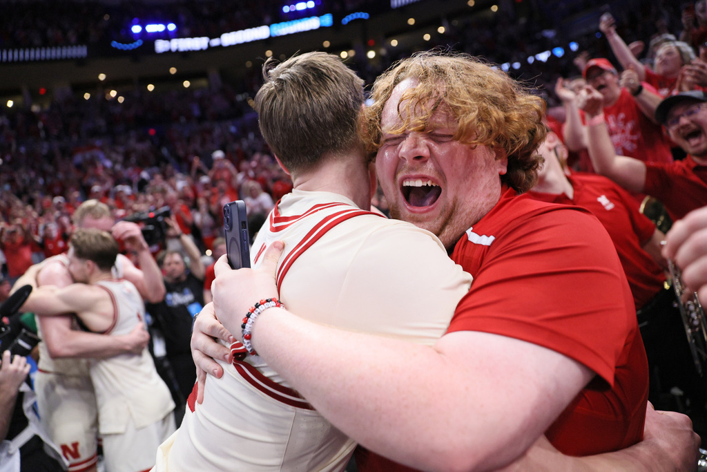 A fan, right, hugs Nebraska forward Braden Frager, left, after a game against Vanderbilt in the second round of the NCAA college basketball tournament, Saturday, March 21, 2026, in Oklahoma City. (AP Photo/Nate Billings)