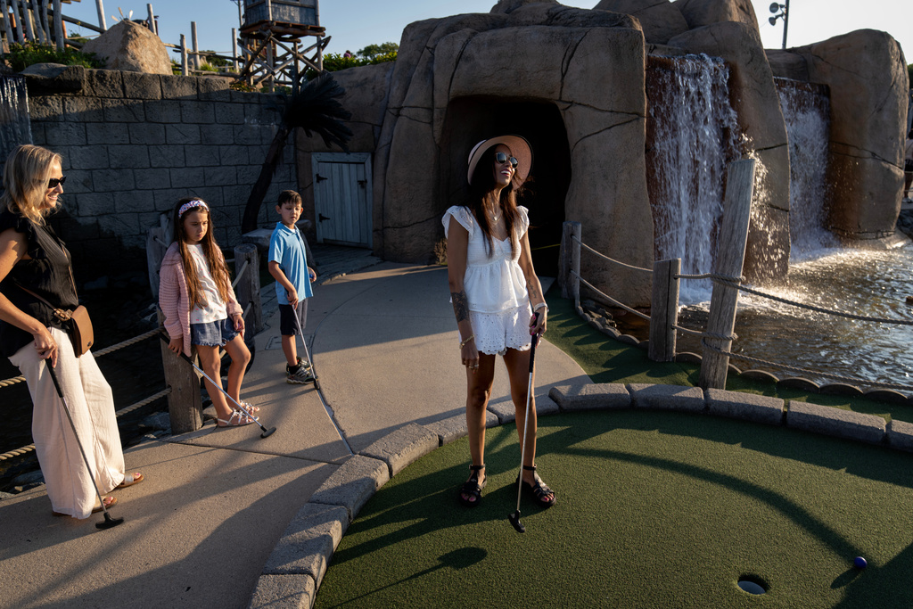 Ruth Wilson, who has lupus, reacts after missing a putt while playing mini golf on vacation with family, Saturday, Aug. 16, 2025, in South Yarmouth, Mass. (AP Photo/David Goldman)