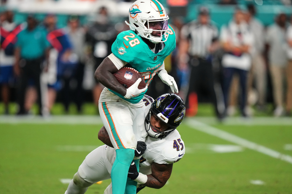 Miami Dolphins running back De'Von Achane (28) is tackled by Baltimore Ravens linebacker Mike Green (45) during the first half of an NFL football game, Thursday, Oct. 30, 2025, in Miami Gardens, Fla. (AP Photo/Lynne Sladky)