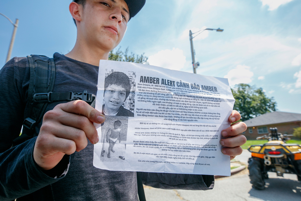 Neighbors and friends of the Vasquez family searched Village De L'East in New Orleans, Sunday, Aug. 17, 2025, for Bryan Vasquez, 12, who has been missing since Thursday. (John McCusker/The Times-Picayune/The New Orleans Advocate via AP)