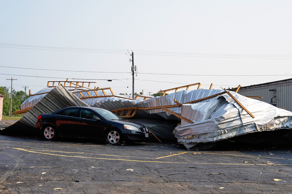 A car sits in a parking lot under a collapsed roof after a tornado struck the day before, Tuesday, July 28, 2026, in Appleton, Wis. (AP Photo/Kayla Wolf)