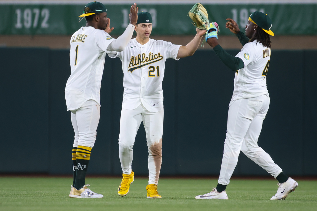 Athletics' Denzel Clarke (1), Tyler Soderstrom (21), and Lawrence Butler celebrate after winning a baseball game against the Texas Rangers, Tuesday, April 14, 2026, in West Sacramento, Calif. (AP Photo/Scott Marshall)